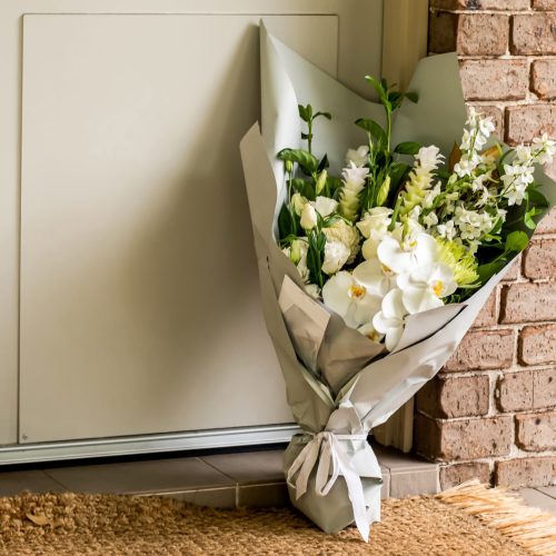 white-flowers-and-a-card-at-doorway-2026-03-16-06-21-04-utc